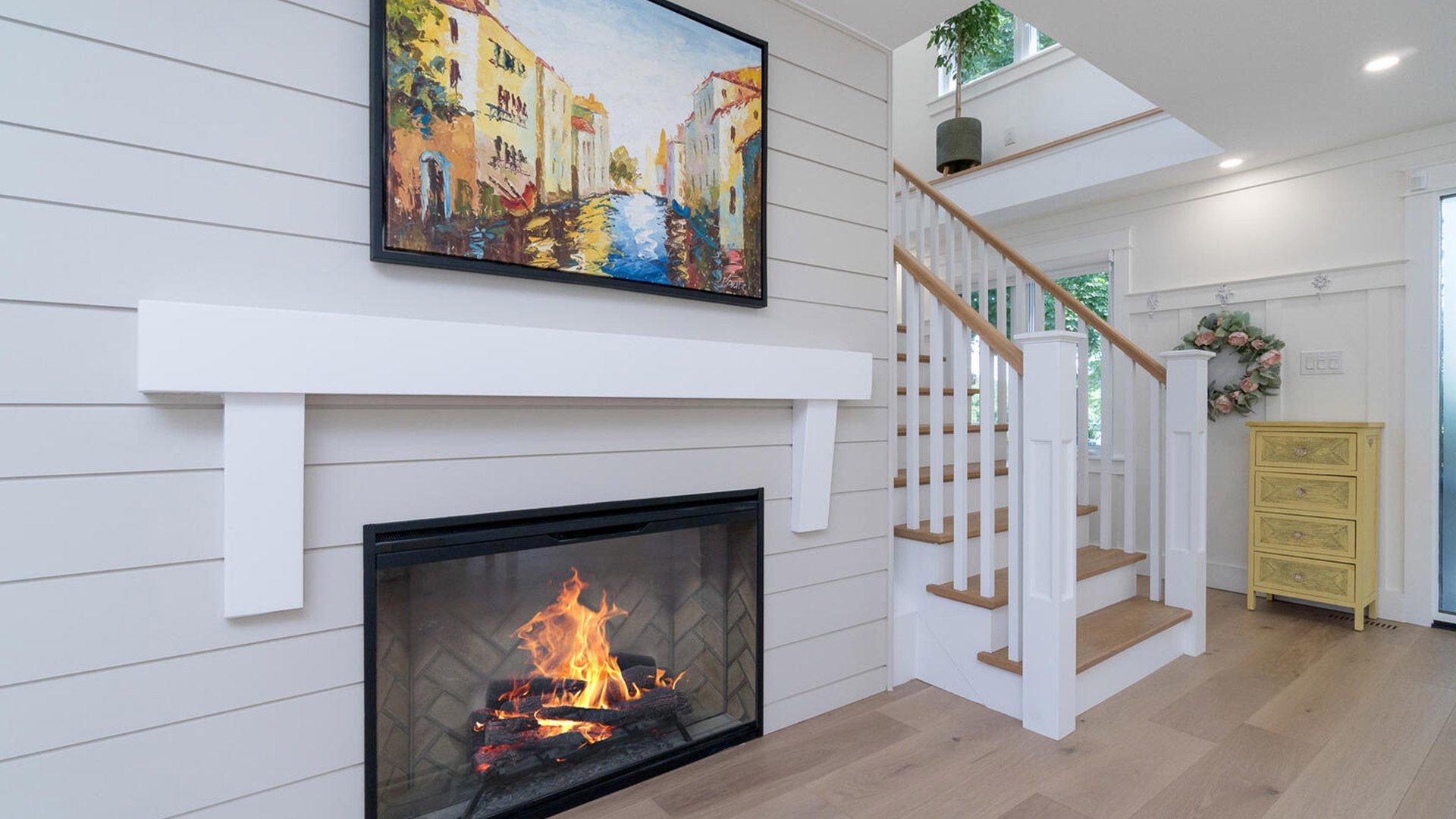 Great room with fireplace and staircase by High Peaks Contracting Ltd.