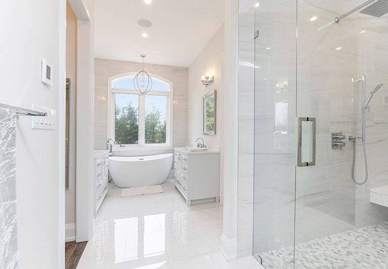 Bright ensuite with freestanding tub and glass shower built by High Peaks Contracting Ltd.